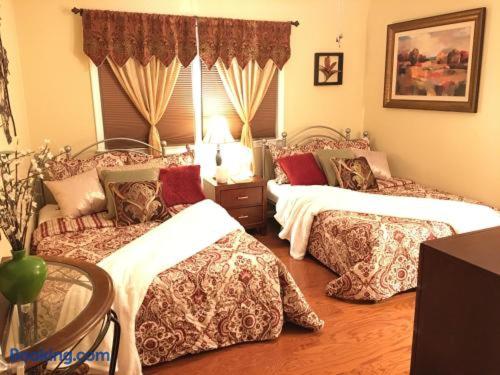 a bedroom with two beds and a table and a window at The Oasis in Clinton