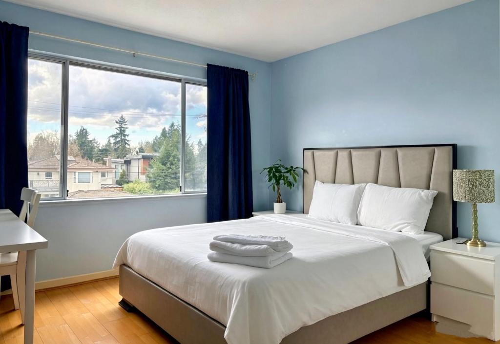a bedroom with a large bed with a large window at Private Ensuite Room Near YVR Airport Vancouver West in Vancouver