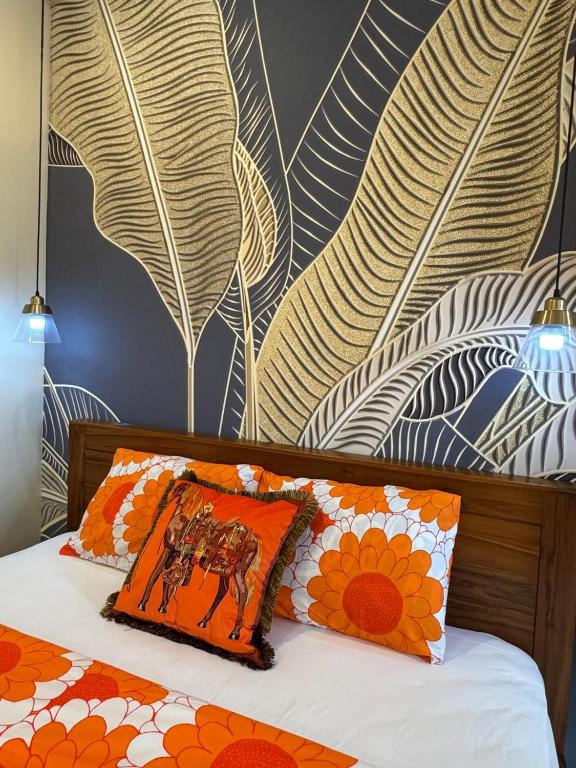 a bedroom with a bed with an orange pillow and flowers at Casa Seraya Dalung in Dalung