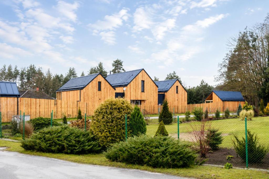 a row of wooden homes with black roofs at Zastávka Vlkov in Vlkov