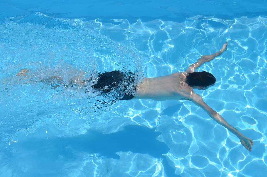 a person swimming in a swimming pool at Geoje Residence Hotel in Geoje