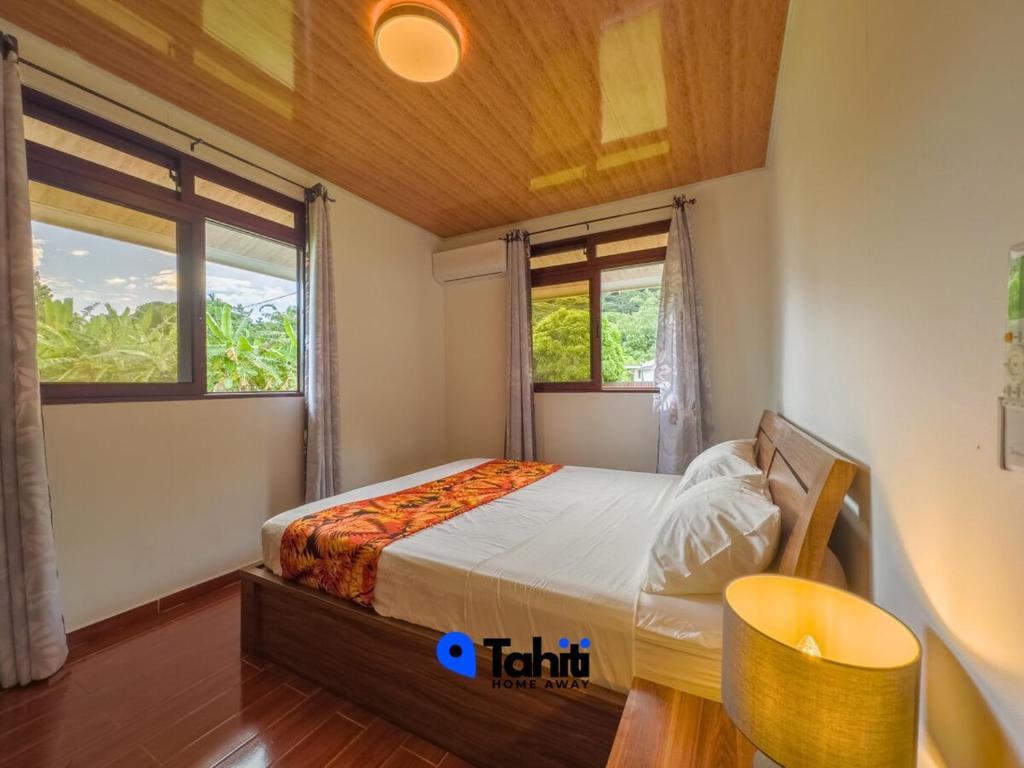a small bedroom with a bed and a window at Moorea Here Lodge house in Atiha
