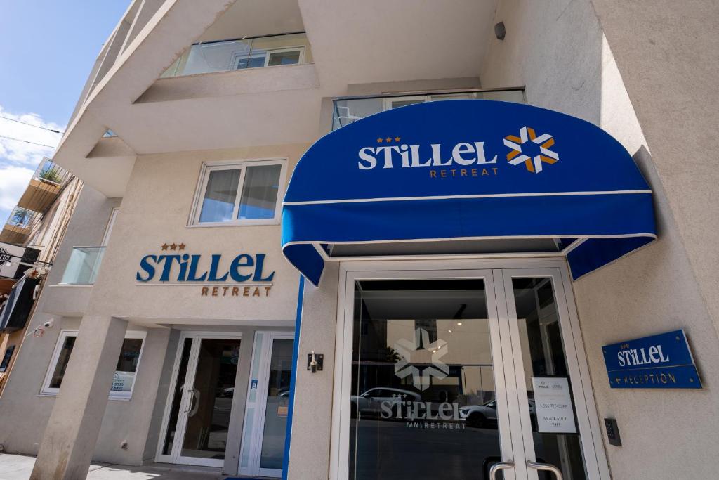 a building with a blue sign on the front of a building at Stillel Retreat Suites in St. Paul's Bay