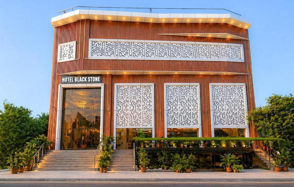 a building with a bench in front of a store at Hotel Black Stone Palace in Ghaziabad