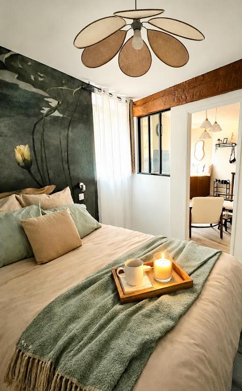 a bed with a tray with two candles on it at Place aux fleurs - Le cocon in Dole