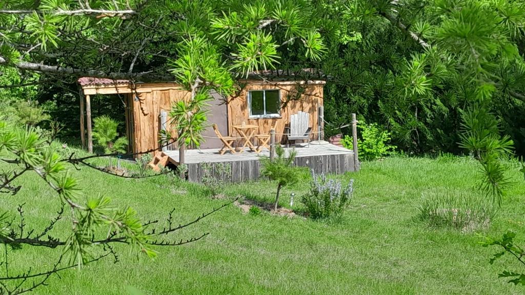 a small wooden cabin with a chair in a yard at Roulotte pour amoureux de la nature in Bugarach