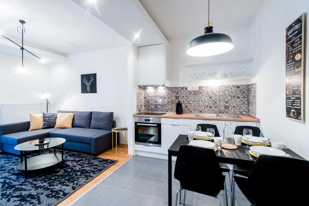 a kitchen and a living room with a blue couch at Vagabond Corvin in Budapest