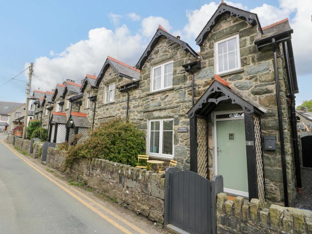 a row of stone houses on the side of a street at Y Bwthyn in Llanbedr