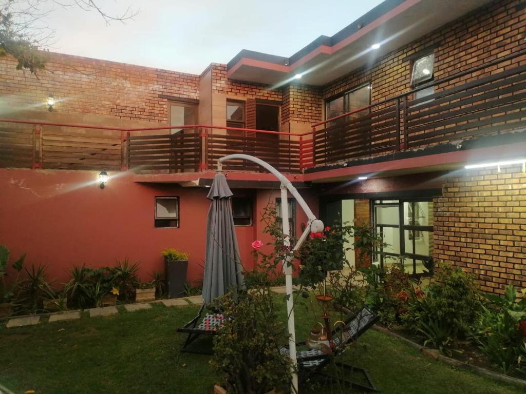 an umbrella in the yard of a house at Dante Guest house in Alberton