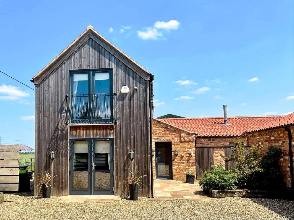 a wooden house with a balcony on top of it at Redroofs Barn - 28184 in Weston