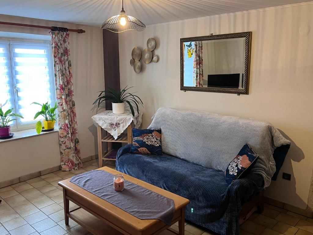 a living room with a blue couch and a table at Chez Mady in Kirschnaumen