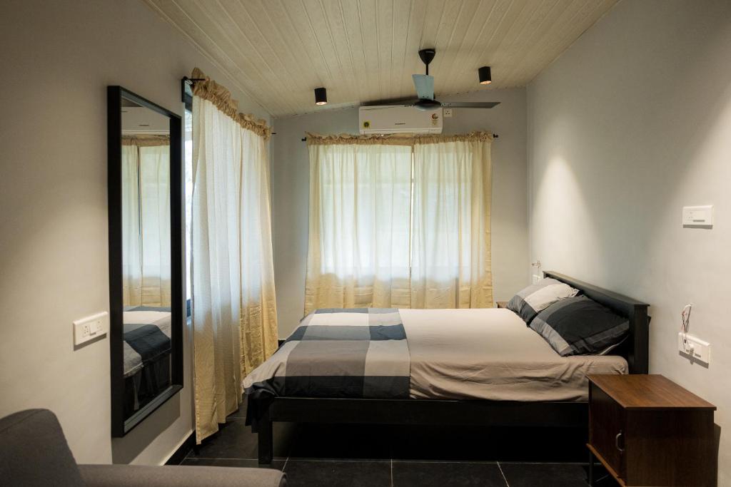 a bedroom with a bed and a mirror and a television at Valhalla Villa in Panvel
