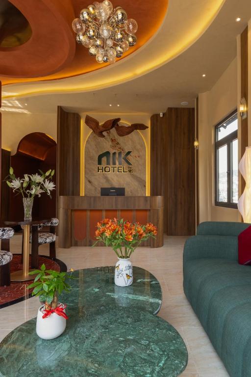 a lobby with a couch and a table with flowers at NiK Hotel Hillside Da Lat in Da Lat