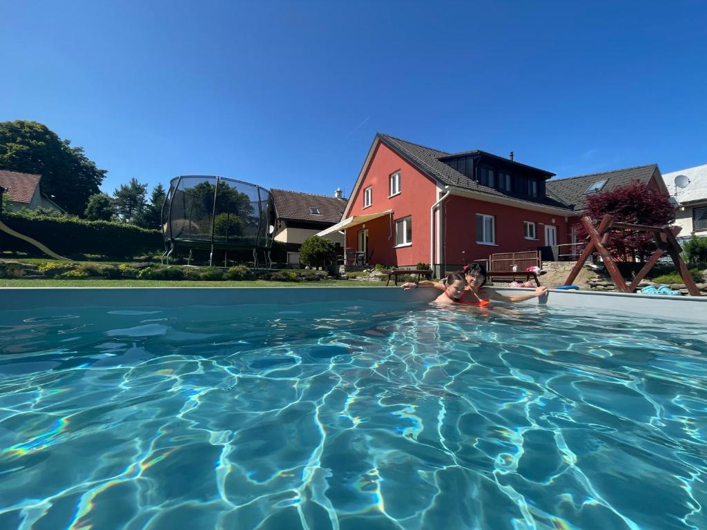a woman swimming in a swimming pool at Red Pine Apartments in Vlachovice