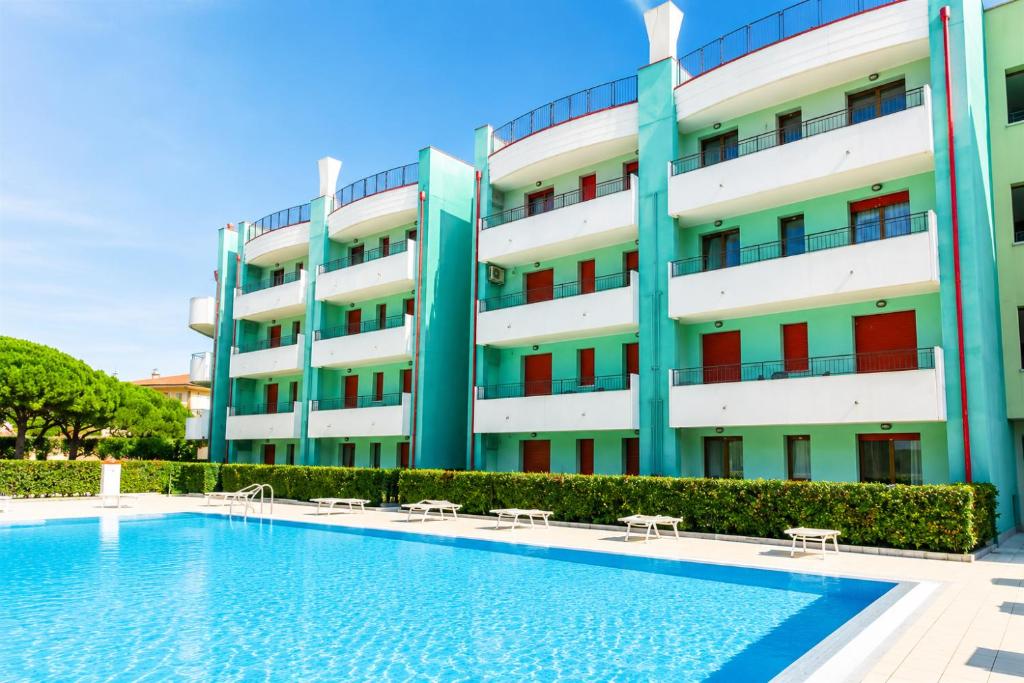 a hotel with a swimming pool in front of a building at Residence Roberta con piscina - Agenzia Cocal in Caorle
