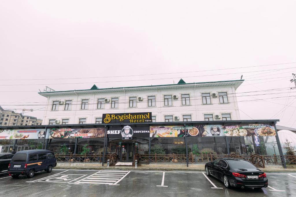 a building with cars parked in front of it at Bog’ishamol Hotel Urgut in Min-Bulak