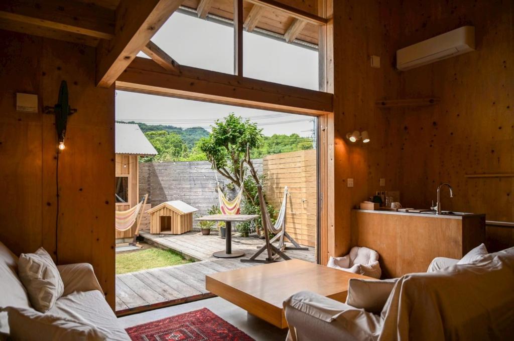 a living room with a large window and a table at anandahの宿 in Miyazaki