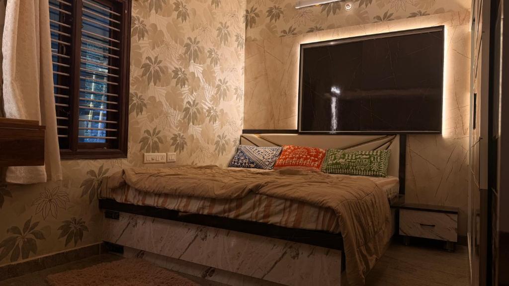 a bedroom with a bed with a large window at Yashaswi Hilldeck in Sondekoppa