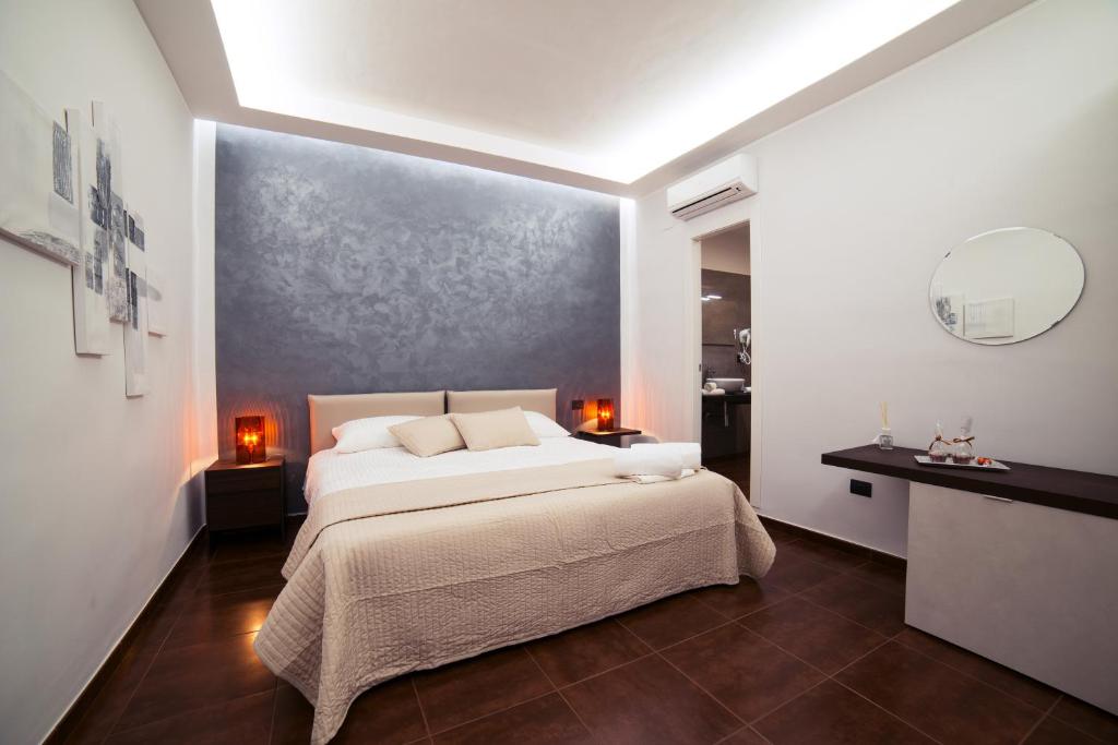 una camera con un letto bianco e un grande muro di Glam House a Salerno