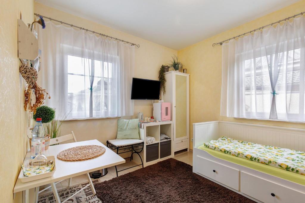 a bedroom with a desk and a bed and a table at Villa am Keltenberg - La Stella in Glauburg