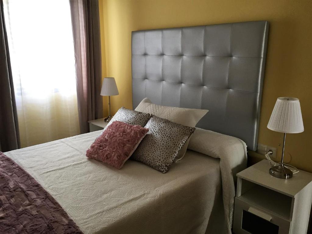 ein Schlafzimmer mit einem großen Bett mit zwei Kissen darauf in der Unterkunft Apartamentos Acevedo Centro I in Ronda