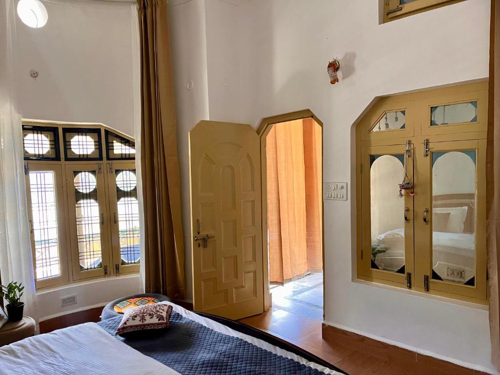 a bedroom with a bed and a mirror and a door at Himora in Gupta Kāshi