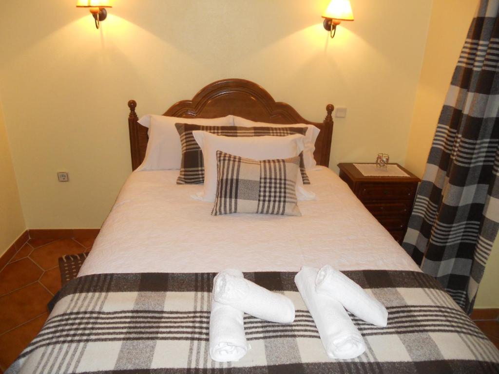 a bed with two pairs of white socks on it at Casas do Castelo in Aldeia da Serra