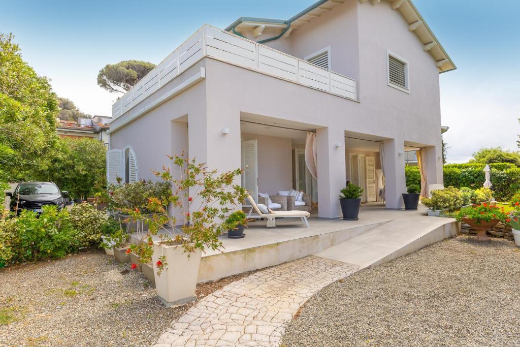 a white house with a patio and some plants at Villa Atusca - Castiglioncello in Castiglioncello