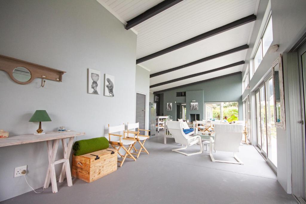 a living room with white chairs and a table at Betty's Bay Cottage in Bettyʼs Bay