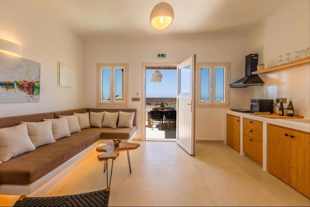 a living room with a large couch and a kitchen at Villa Karras - Sea & Mountain View in Perissa