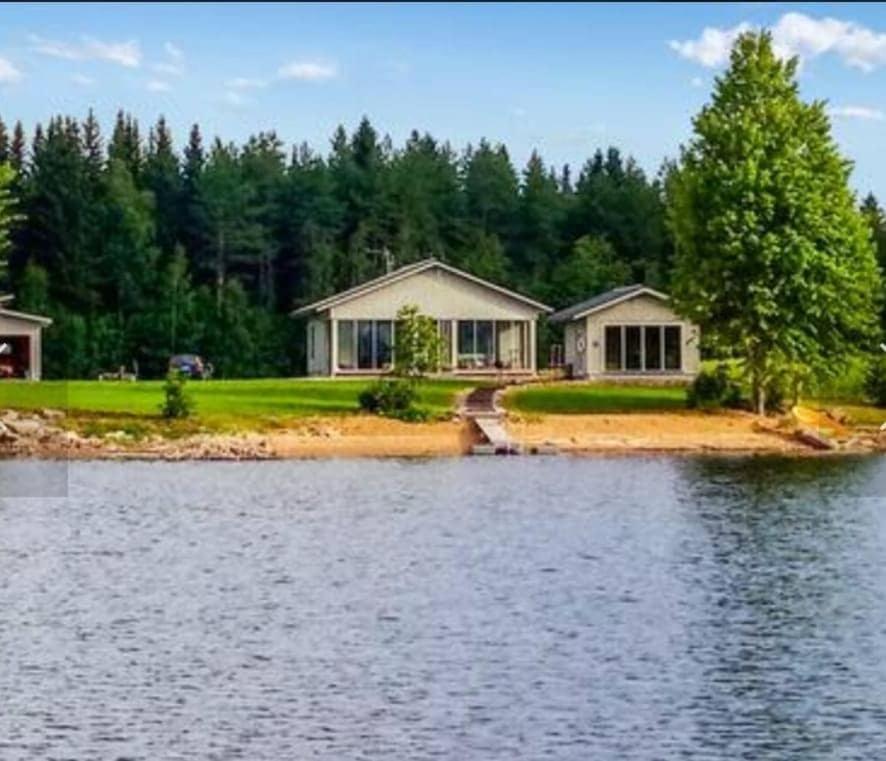 a house on the shore of a body of water at Paris Beach in Saarijärvi