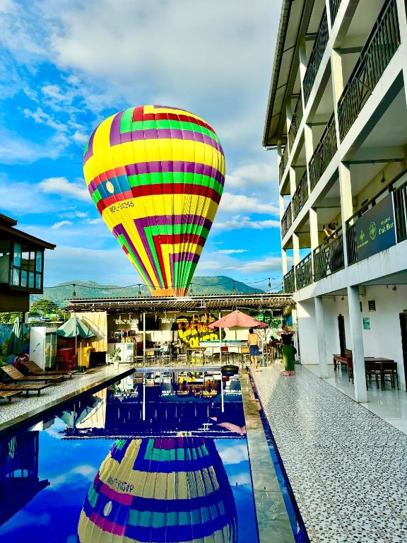 a hot air balloon flying over a swimming pool at Santara Hostel in Vang Vieng