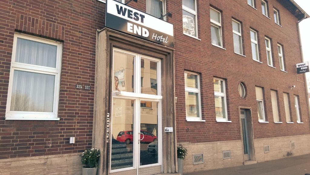 a store front of a brick building with a red car in the window at Hotel Westend in Cologne