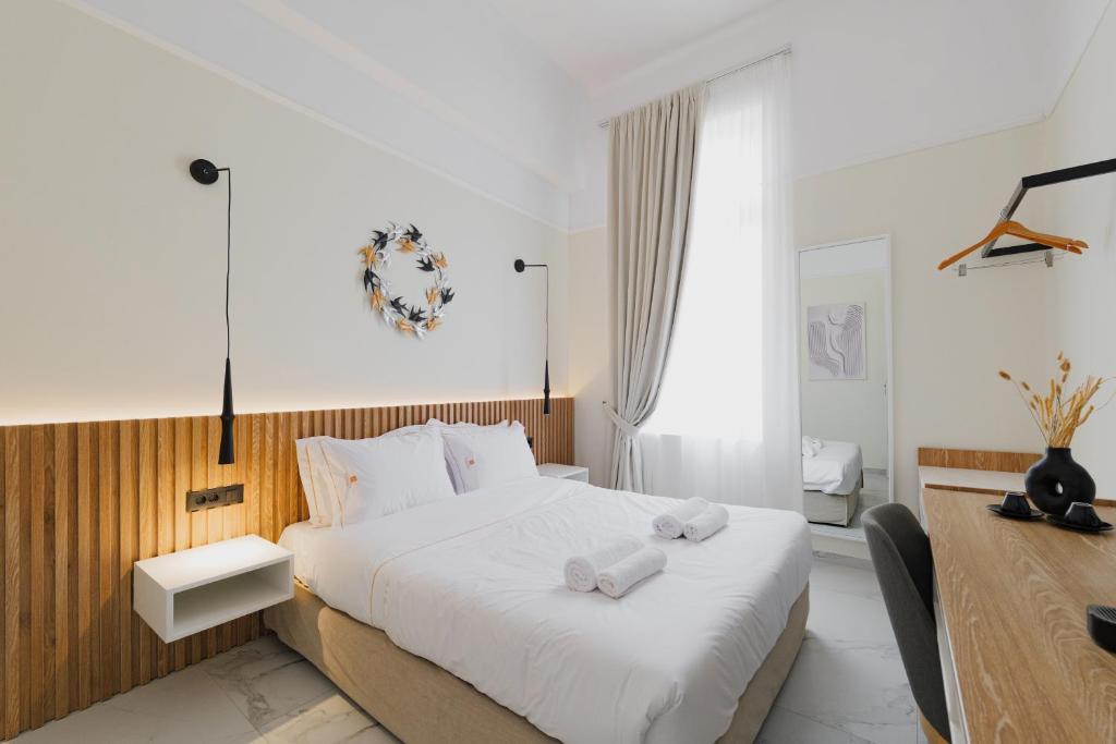 a bedroom with a bed with two towels on it at Kismet Urban Boutique in Heraklio