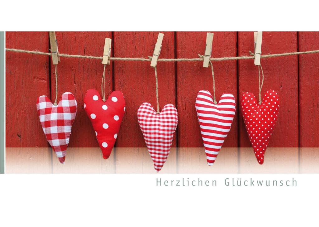 four red and white hearts hanging on a wall at Boutique Hotel Lohspeicher 1839 in Cochem