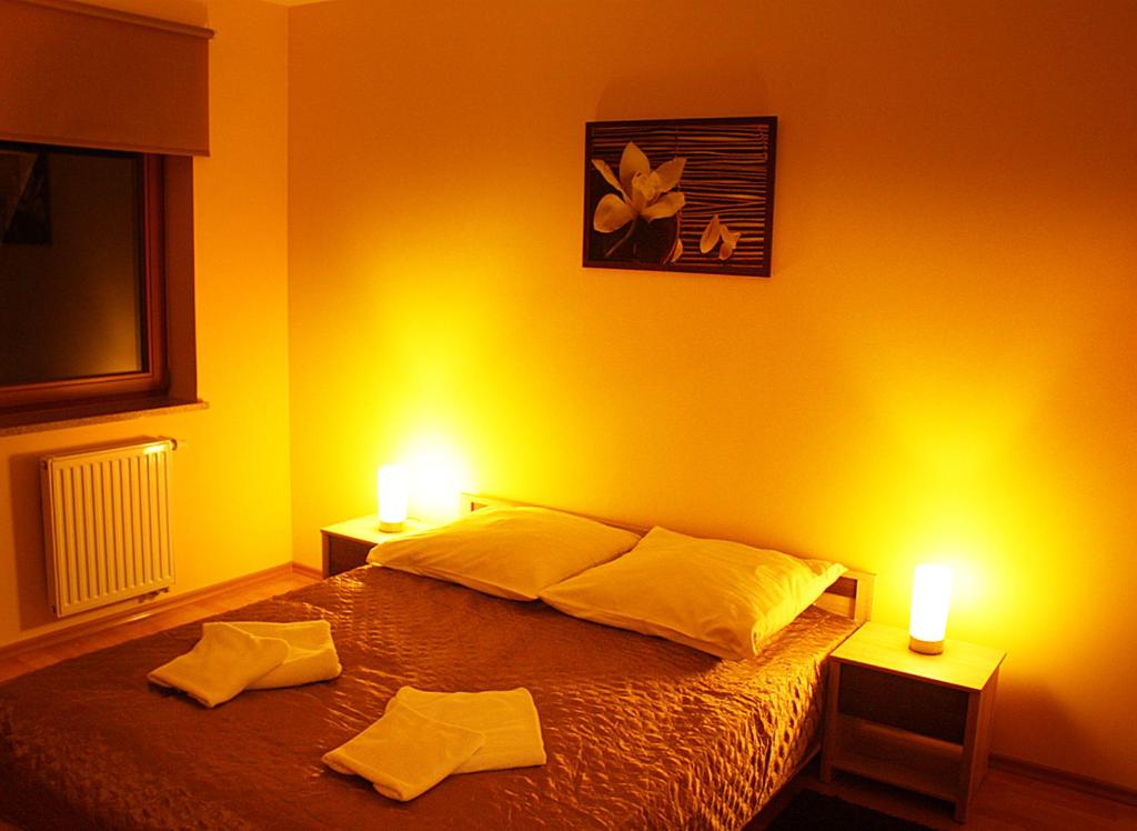 シュチェチンにあるApartament Luxusのベッドルーム1室(ベッドにキャンドル2本付)