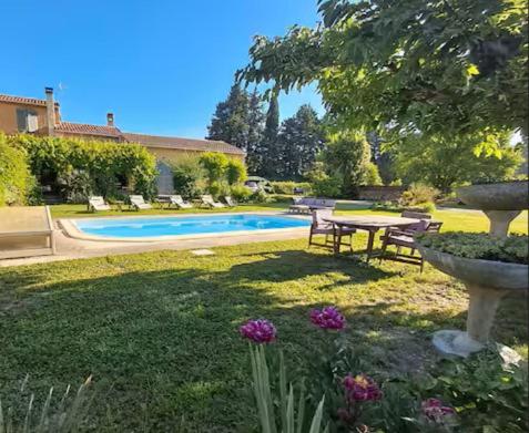 a yard with a picnic table and a swimming pool at Chez Diane et Bruno in Pernes-les-Fontaines