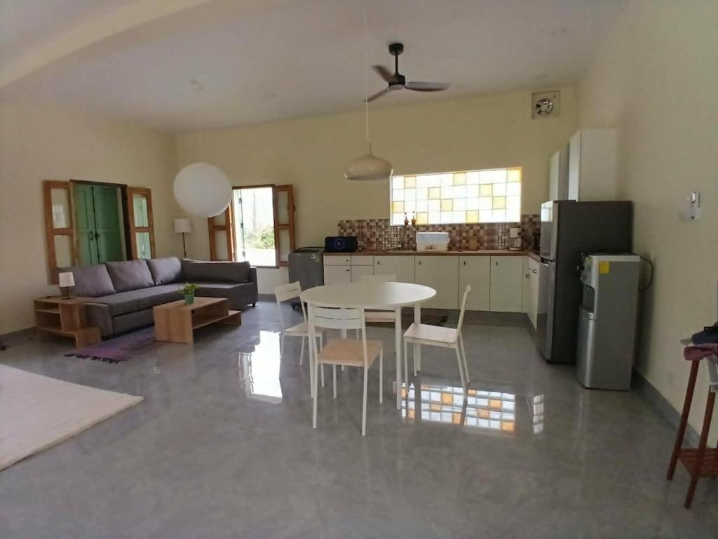 a living room with a table and a kitchen at Half Way Villa in Luang Prabang