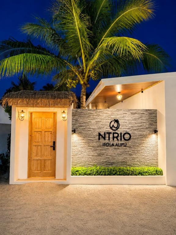 a sign for a nirico hotel with a palm tree at Isola Alifu in Feridhoo