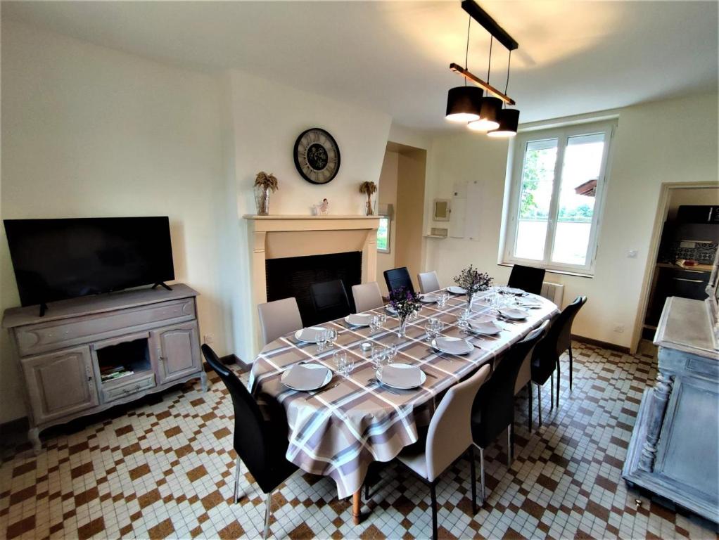 a dining room with a table with chairs and a television at Gîte G4144 in Saint-Pierre-de-Varengeville