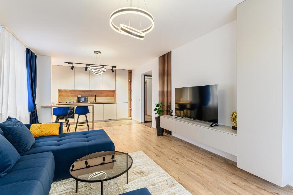 a living room with a blue couch and a tv at MoHost Blue Moon Apartments in Braşov