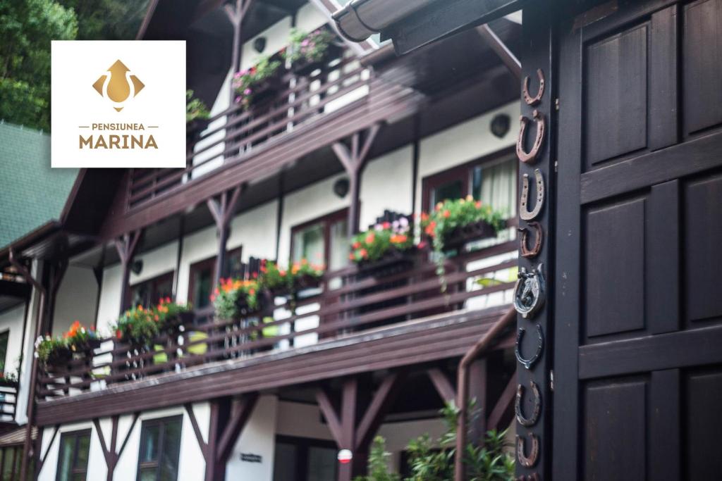 un bâtiment avec des boîtes de fleurs sur les balcons dans l'établissement Pension Marina, à Sinaia