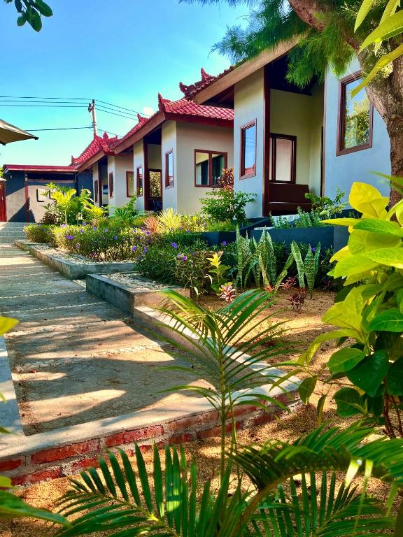 a row of houses in a garden with plants at Secret Garden Surf Resort, walk to waves in Pulau Gilkaliantan