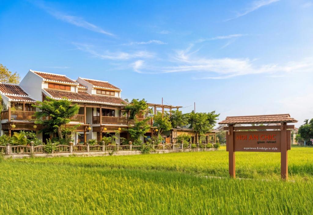 a sign in a field in front of a house at Hoi An Chic - Green Retreat in Hoi An