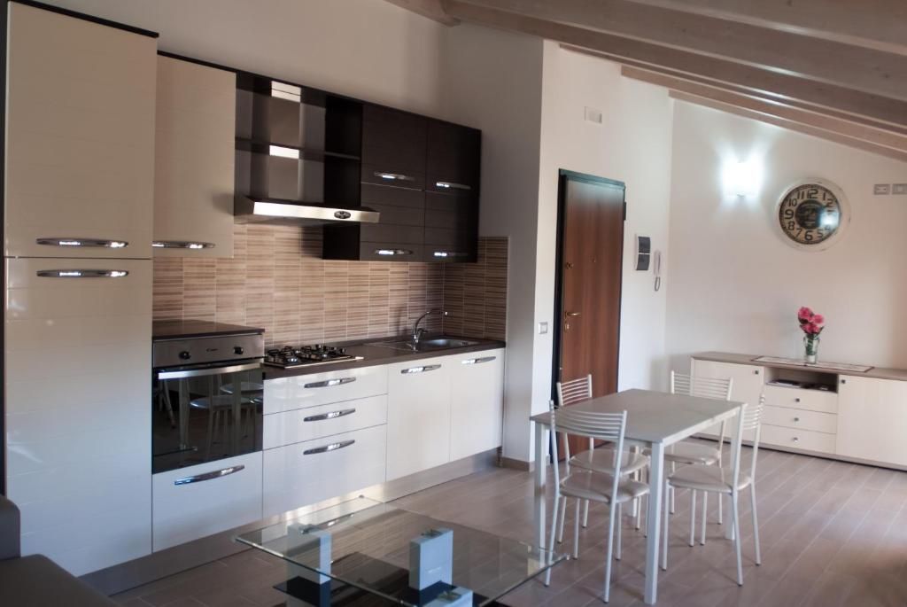 eine Küche mit weißen Schränken und einem Tisch mit Stühlen in der Unterkunft Casa vacanza Leucosia&Tresino in Santa Maria di Castellabate