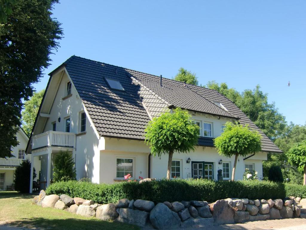 a white house with a black roof at Auszeit auf Rügen Haus Nr. 8 in Nardevitz