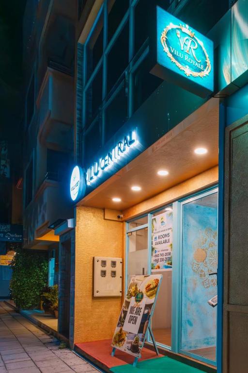 a sign in front of a building with a restaurant at Vilu Central in Hulhumale