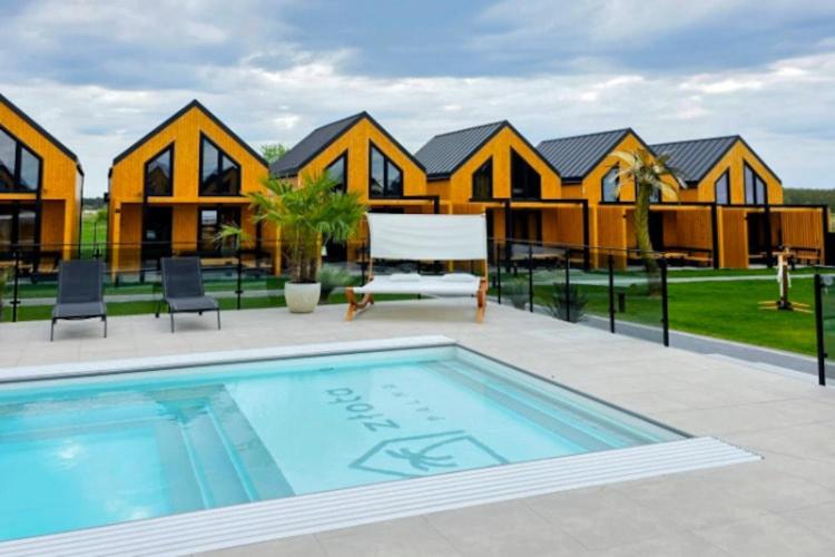 a large swimming pool in front of a house at Comfortable holiday home, pool, sauna, jacuzzi in Kopań