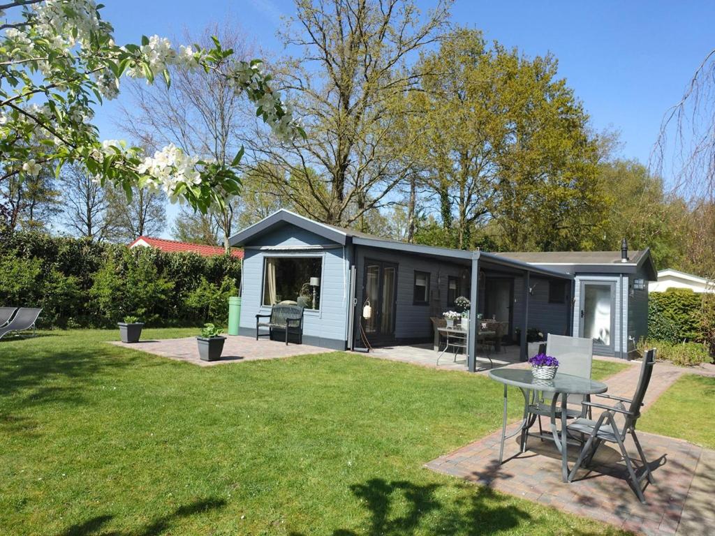 a small house with a table in a yard at Vechtdal Chalet de Wilg in Rheezerveen