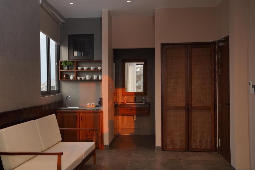a living room with a white couch and a door at HOA GIO Boutique stay in Hue